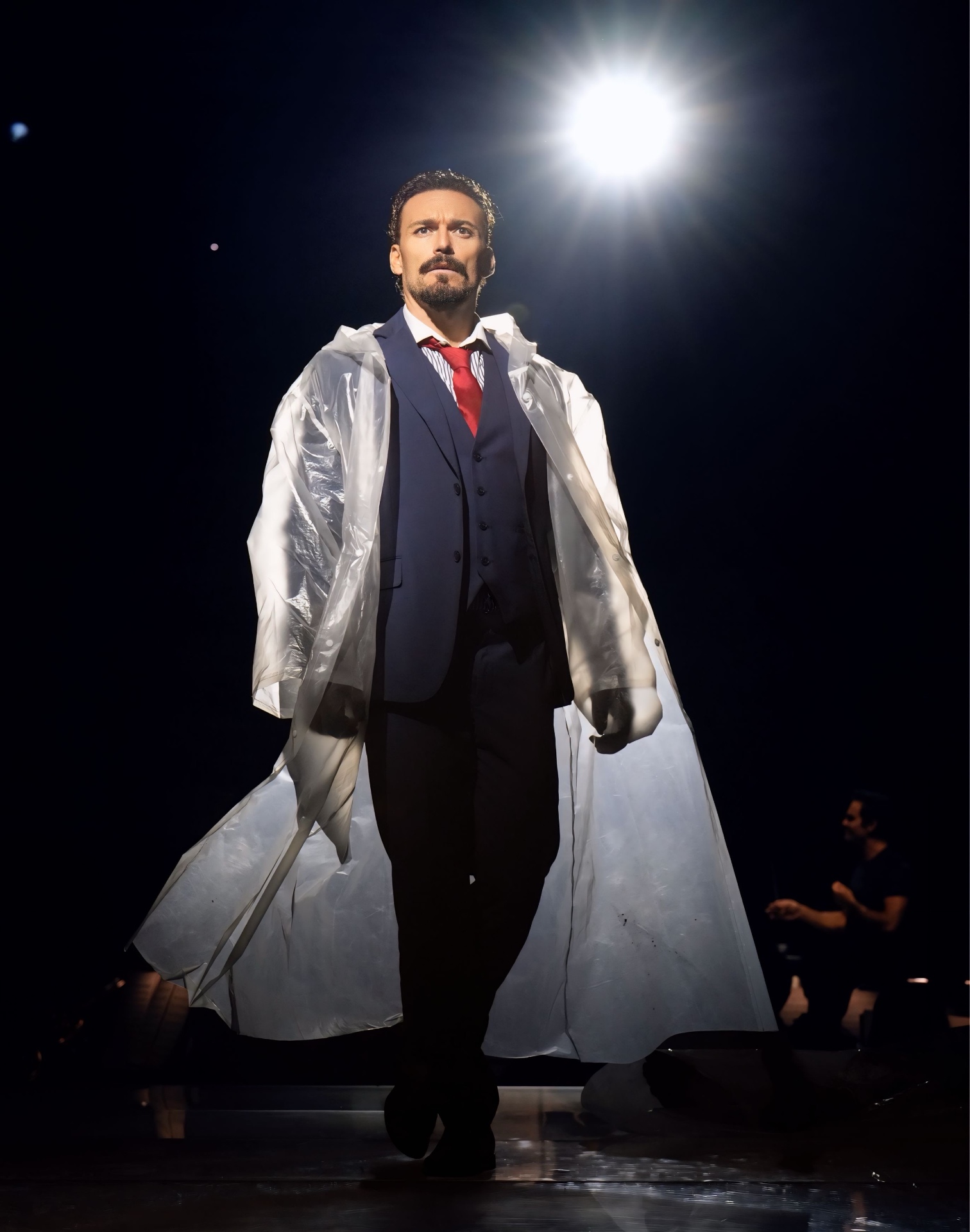 Gianluca Margheri on stage under a single spotlight