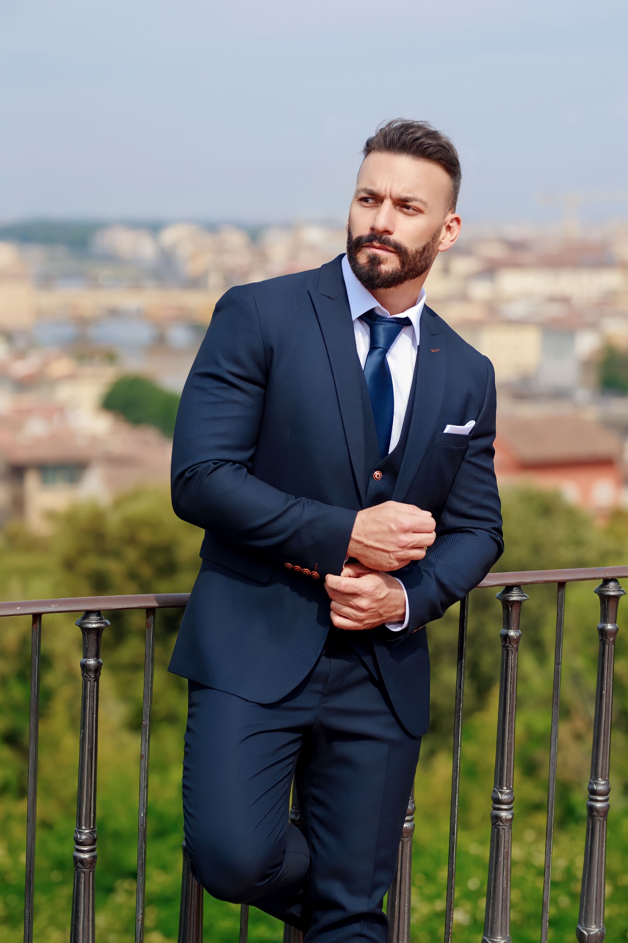 Gianluca Margheri in a navy three-piece suit on a terrace overlooking Florence